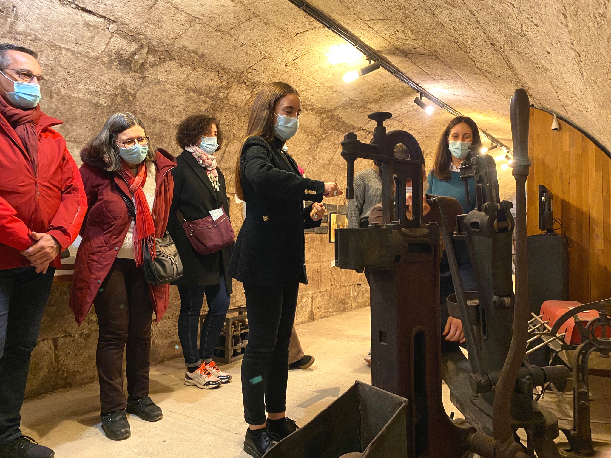Une guide dévoilant les secrets du vignoble bordelais à des participants lors d'une visite guidée du musée du vin et du négoce de Bordeaux.